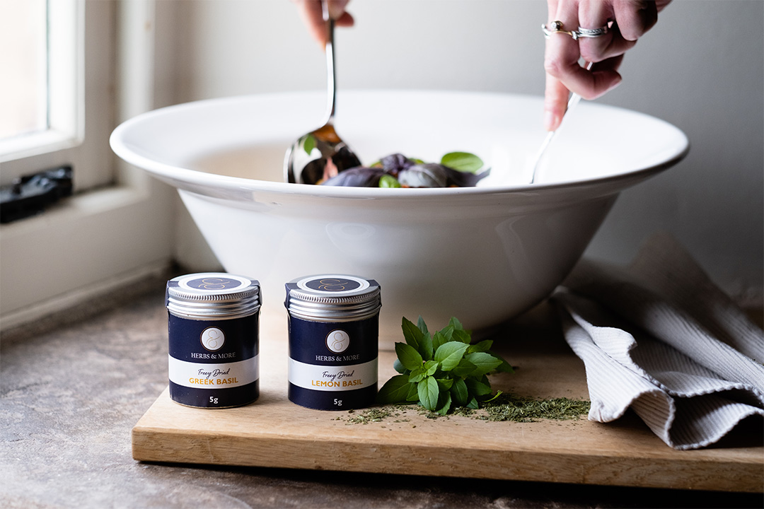 Blue and silver herb tins with mediterranean vegetable sauce in bowl in background